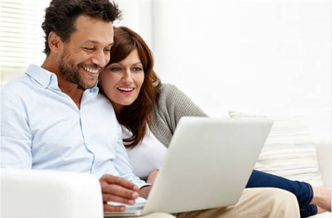 Dos personas en un sillon con una laptop